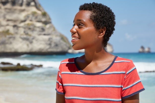 Photo gratuite tir horizontal d'adolescent à la peau foncée aux cheveux courts bouclés