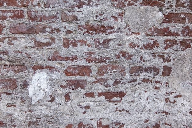 Tir horizontal d'un vieux mur de pierre rouge et blanc avec de la texture et du plâtre dessus