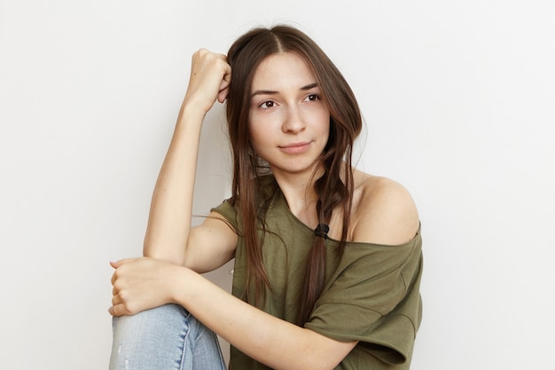 Tir intérieur de la belle jeune femme brune en vêtements élégants