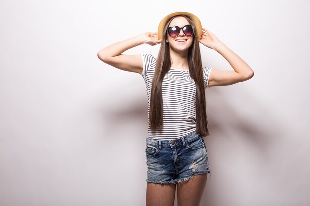 Tir intérieur d'une joyeuse jeune femme européenne fait semblant de danser, porte un chemisier à la mode, un chapeau et un short, recrée pendant l'heure d'été