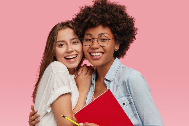 Tir isolé de jeunes camarades de groupe femmes amicales multiethniques embrasser