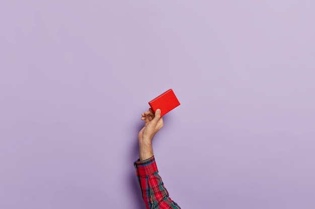 Tir isolé des mains de l'homme avec une petite boîte de papier rouge vide pour accessoire