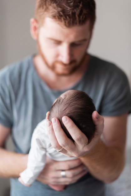 Tir moyen floue père tenant bébé