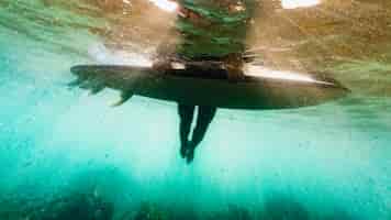 Photo gratuite tir subaquatique d'une femme avec une planche de surf