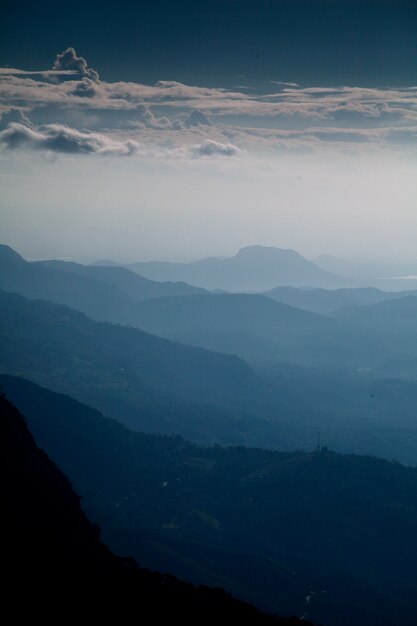 Tir vertical de la belle chaîne de montagnes et du ciel nuageux tôt le matin