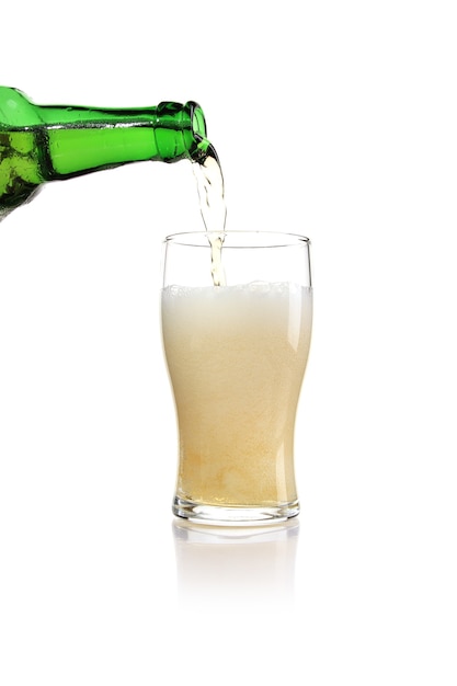 Tir vertical de bière d'une bouteille verte versée dans un verre