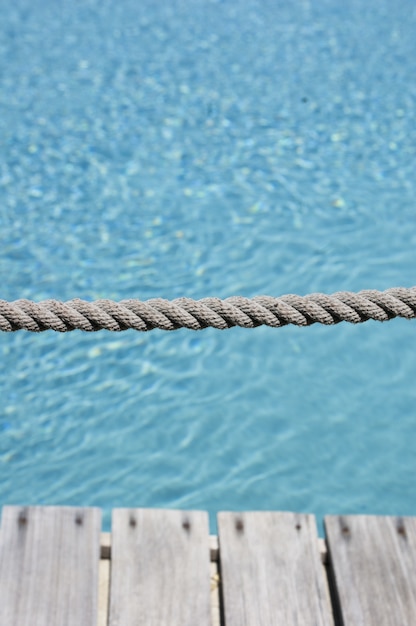 Tir vertical d'une corde grise avec le fond de l'eau claire dans la piscine