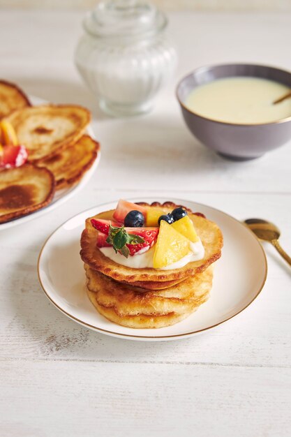 Tir vertical de délicieuses crêpes aux fruits sur le dessus au petit déjeuner