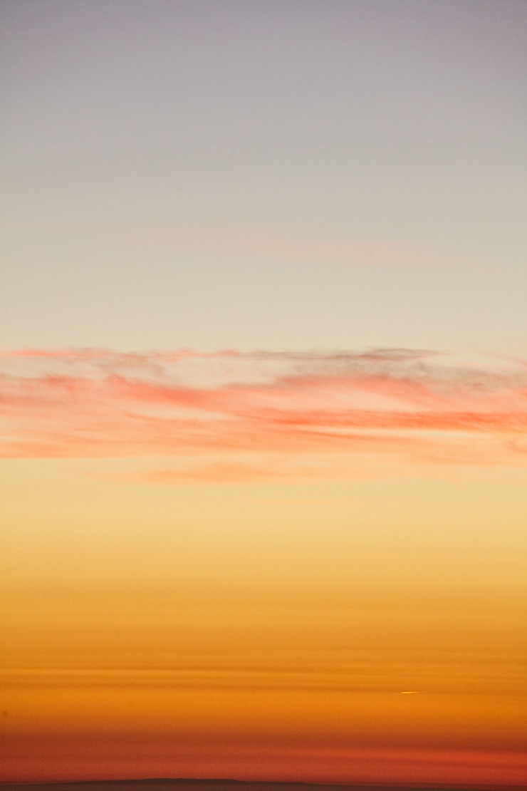 Photo gratuit tir vertical du ciel coucher de soleil doré sur l'océan pacifique