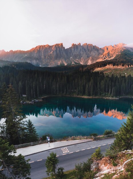 Tir vertical du lac Carezza entouré par les Dolomites et la verdure du Tyrol du Sud Italie