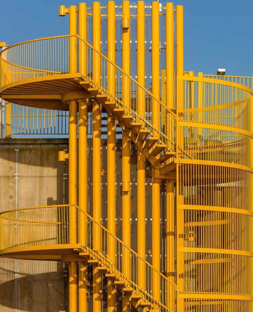 Tir vertical d'un escalier en colimaçon jaune sous la lumière du soleil