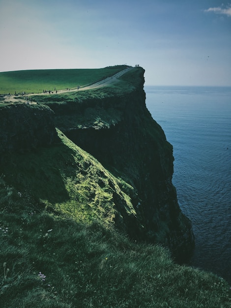 Photo gratuite tir vertical d'une falaise avec un chemin dans la mer