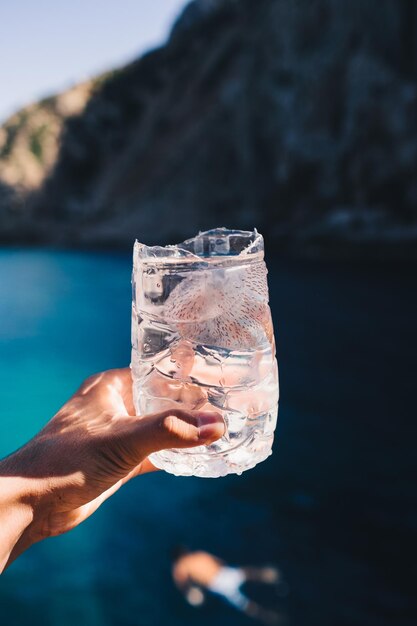 Le tir vertical d'un homme garde un cocktail frais sur le fond de l'océan