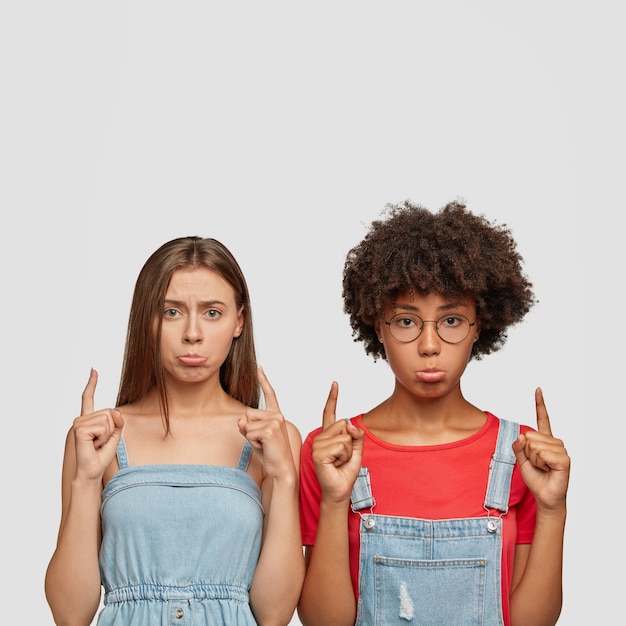 Photo gratuite tir vertical à l'intérieur de femmes tristes mécontents sac à main lèvres inférieures