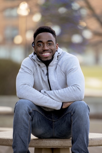 Tir vertical d'un joli homme afro-américain souriant devant la caméra