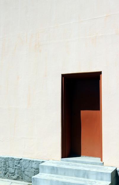 Tir vertical d'une maison blanche avec une porte brune sur une journée ensoleillée