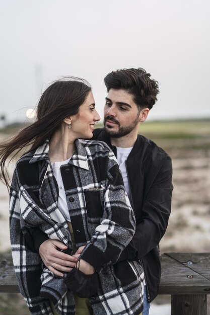 Tir vertical d'un mignon couple caucasien espagnol se regardant avec amour, à l'extérieur