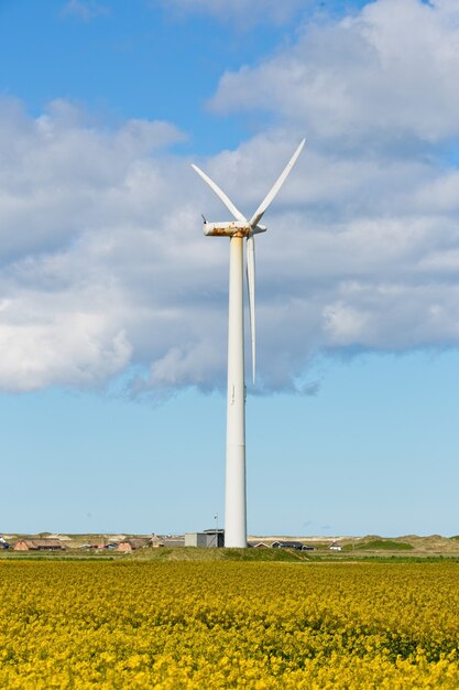 Tir vertical d'un moulin à vent dans un champ sous un ciel nuageux