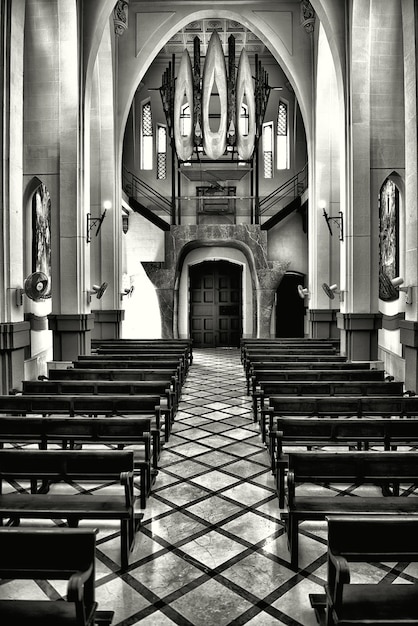 Photo gratuite tir vertical en niveaux de gris de l'intérieur d'une ancienne église chrétienne historique