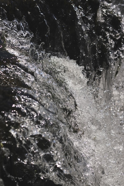 Tir vertical en noir et blanc d'un jet d'eau éclaboussant