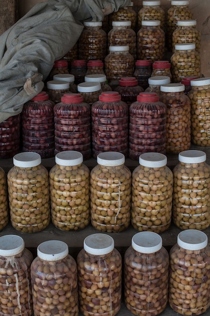 Tir vertical de nombreuses bouteilles en plastique avec des couvercles blancs pleins de diverses petites récoltes