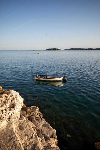 Tir vertical d'un petit bateau sur un océan bleu