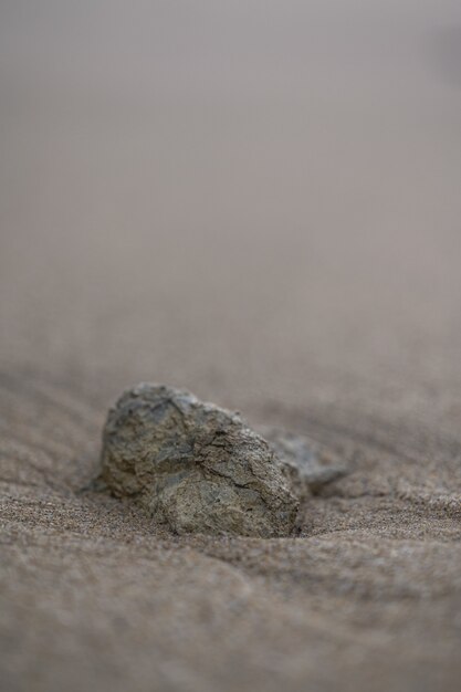 Tir vertical d'une pierre sur une plage de sable