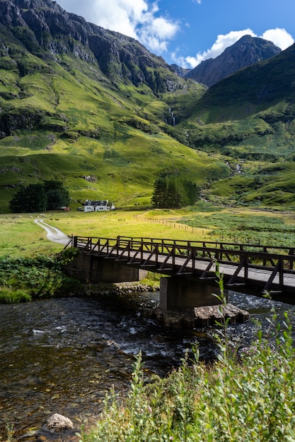 Tir vertical d'un pont sur la rivière entouré par les montagnes en Ecosse