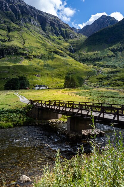 Tir vertical d'un pont sur la rivière entouré par les montagnes en Ecosse