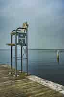 Photo gratuite tir vertical d'une station de sauvetage dans le quai avec une mer ouverte et un ciel sombre en arrière-plan