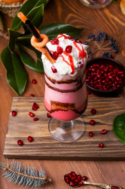 Tiramisu aux fraises et mousse à la crème avec pépites de granulés dans un verre. Sur table en bois