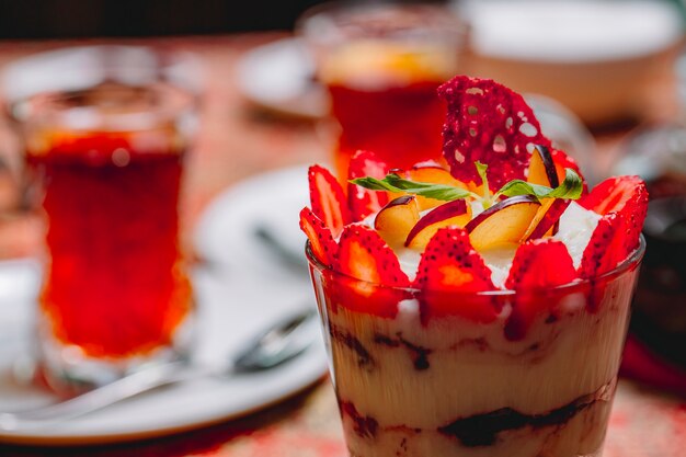 Tiramisu dessert vue de côté avec des fraises en tranches et pomme