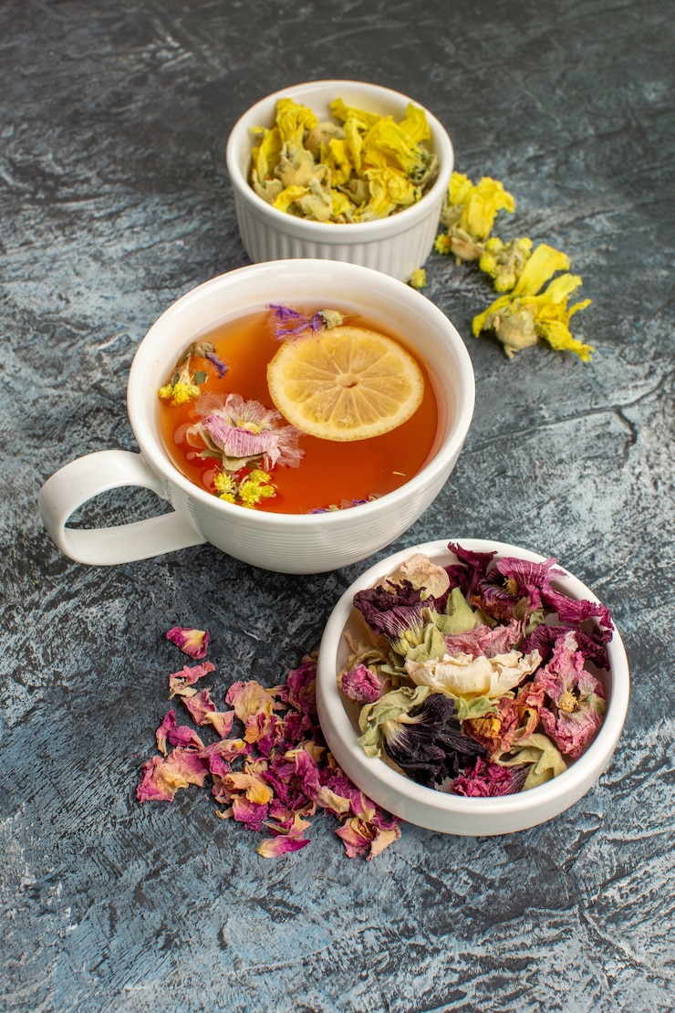 Photo gratuit tisane aux fleurs séchées et une assiette sur fond gris