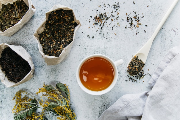 Tisane séchée avec une tasse de thé sur fond de béton