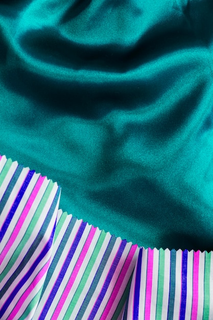 Tissu multicolore sur fond textile vert soyeux