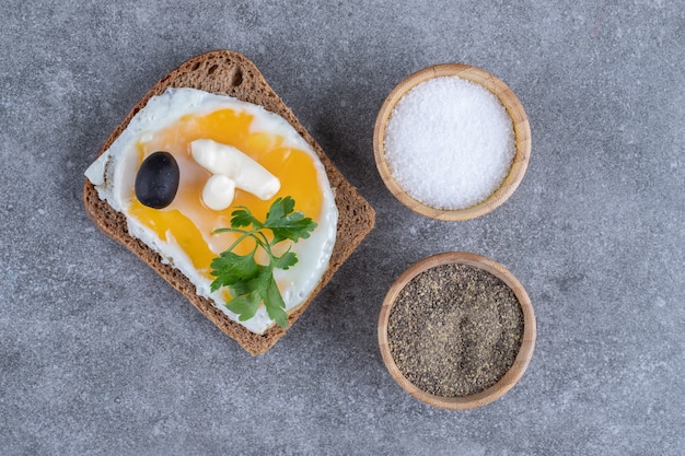 Toast avec des bols en bois de sel et de poivre