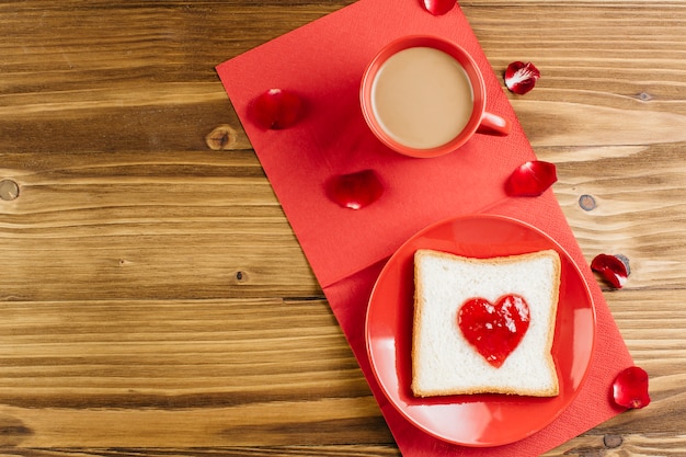 Toast avec de la confiture en forme de coeur sur plaque rouge