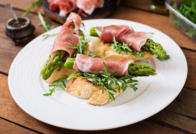 Toasts aux asperges, roquette et prosciutto.