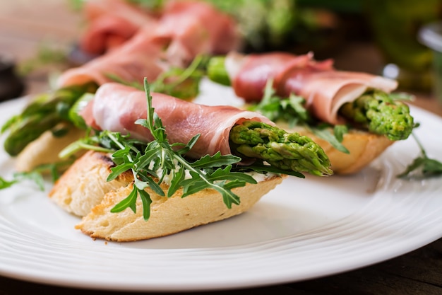 Photo gratuite toasts aux asperges, roquette et prosciutto.