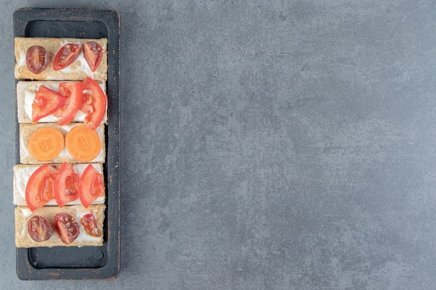 Toasts croustillants aux tomates sur planche de bois.