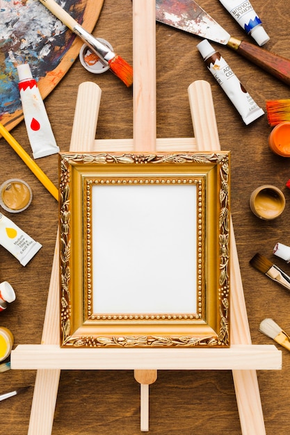 Photo gratuite toile vide dans un cadre doré et vue de dessus de peinture