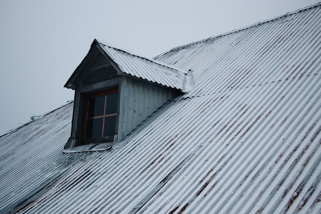 Photo gratuite toit du bâtiment couvert de neige contre le ciel nuageux