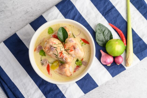 Tom Kha Kai Dans Un Bol Avec Des Feuilles De Lime Kaffir, De La Citronnelle, De L'oignon Rouge, Du Galanga Et Du Piment.