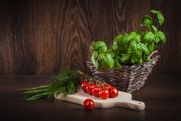 Tomate cerise et herbes fraîches vertes sur bois