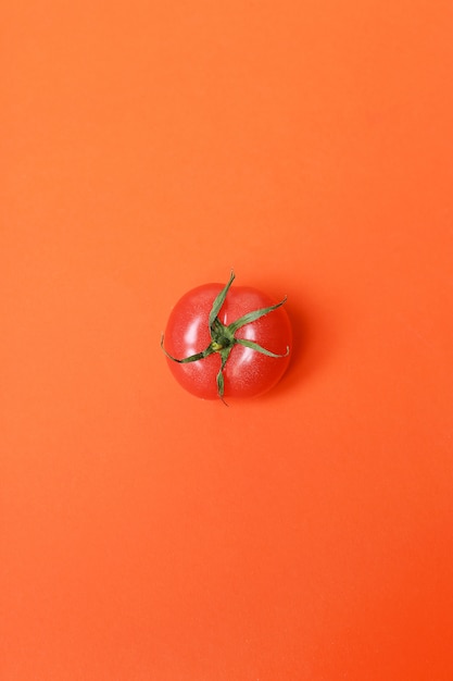 Tomate isolée sur une surface rouge