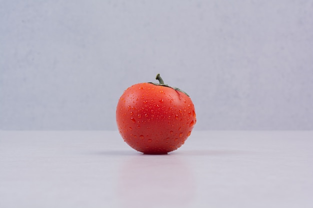 Tomate rouge fraîche sur une surface blanche