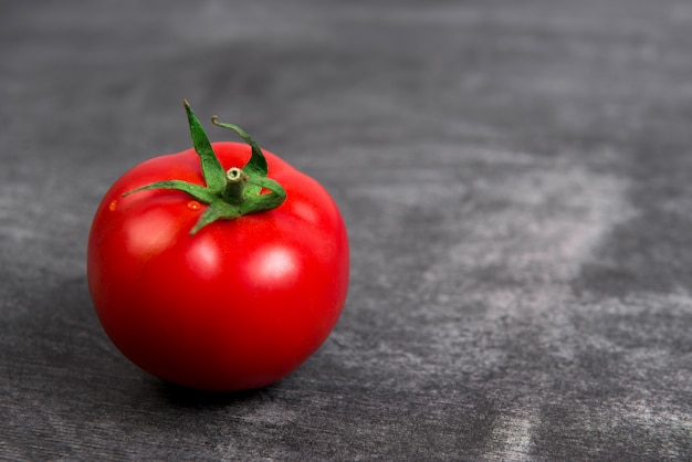 Tomate rouge sur table gris en bois