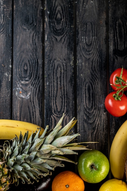 Photo gratuite tomates ananas et bananes sur une table en bois