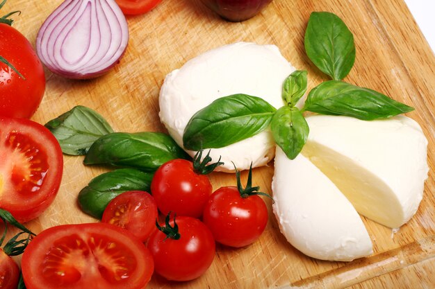 Tomates, basilic et mozzarella sur planche de bois