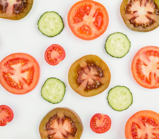 Photo gratuite tomates biologiques avec tranches de concombre